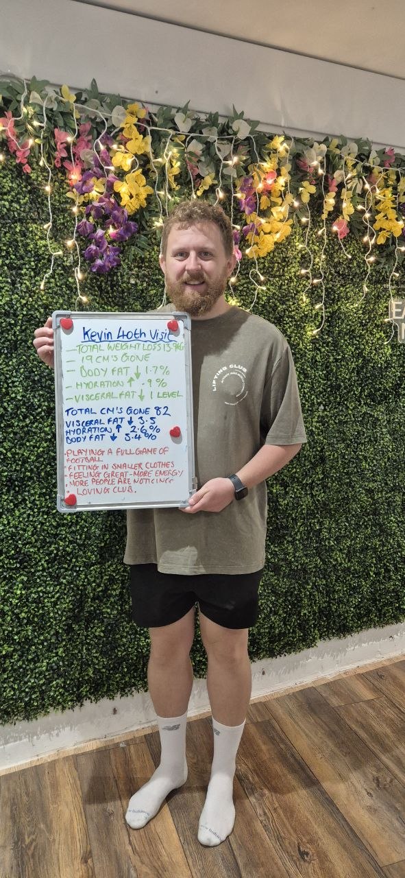 Kev holding his 40th-visit review board, celebrating 82 cm lost and progress with football, energy and smaller clothes